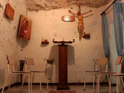 Di fronte poi, intorno a cinque sedie, si trova un leggio su cui � appoggiato un libro di letture religiose: � sovrastato da una statua di Cristo e da due icone in legno con motivi ortodossi-orientali